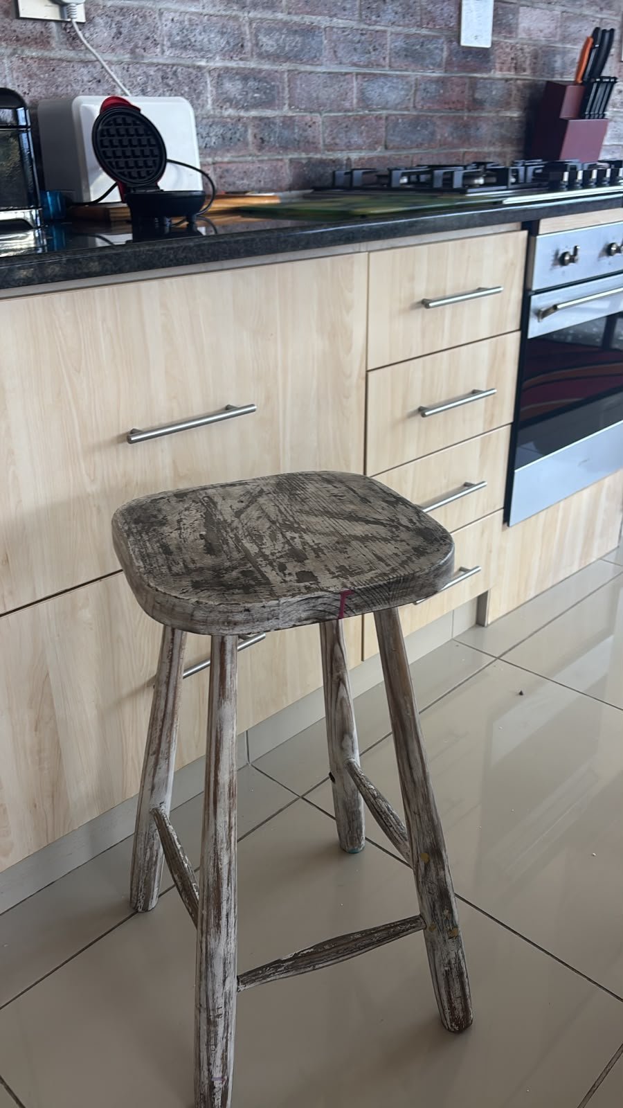 The counter-height wooden stool I sit on in my kitchen
